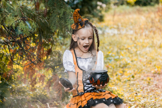 Girl Enjoys Halloween Activities in Autumn With Pumpkins and Spiderwebs on a Sunny October Day in the Park