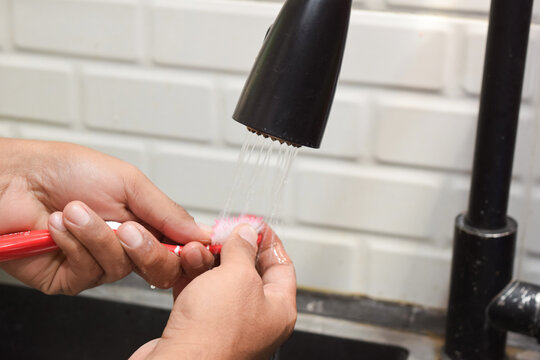 Close up a man washing toothbrush after using