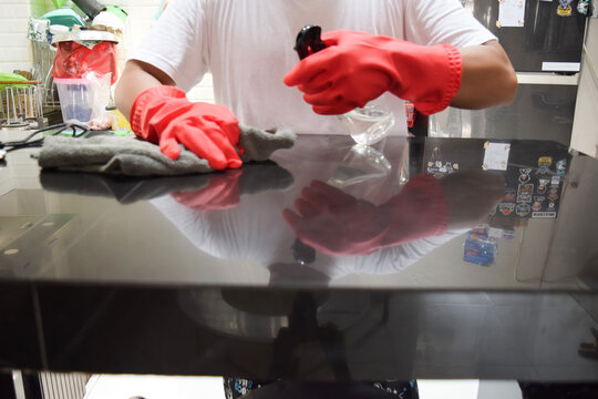 Young husband in household concept. A man cleaning kitchen