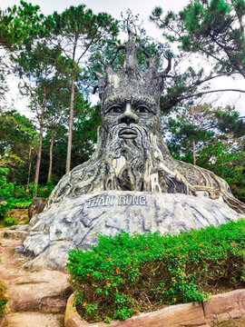 Forest God sculpture at God Valley near Da Lat, Vietnam. The giant tree spirit stands among pine trees. Suitable for travel guides, tourism, fantasy attractions and nature articles