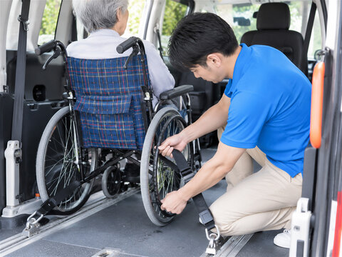 車椅子を車内で固定する介護タクシースタッフ【49個】