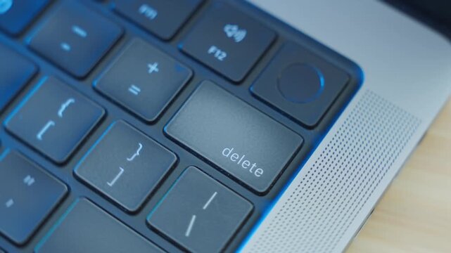 Close up on Delete key as finger clicks it multiple times erasing data or text. Person or user deleting information or removing files from digital system or database. Private personal data erased