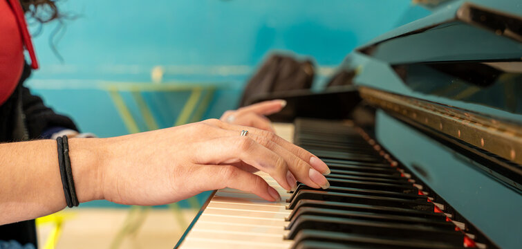Hands playing piano keys creating music harmony