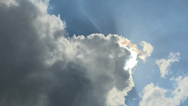 Sun Rays Shining Through Dramatic Clouds in a Blue Sky