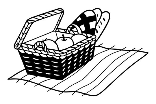 Wicker picnic basket with bread, apples and cheese on a blanket