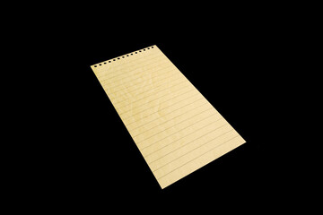 Notebook paper page isolated on black JPEG background, lying on a shelf. © vovan