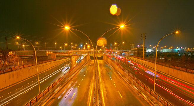 A night view of the Seyrantepe highway overpass and underpass junction in Diyarbakır, captured using the long-exposure technique and featuring vehicle light trails.