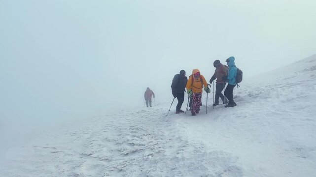 Exhausted mountaineer being supported by companions in wide view on snowy Mount Ararat near the summit, showing team assistance, high-altitude fatigue, expedition safety, endurance