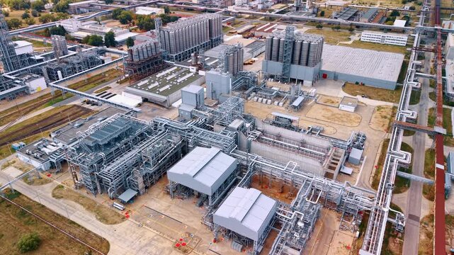 Large industrial complex at daytime. A high-angle aerial view of a modern industrial plant or refinery with complicated pipelines.