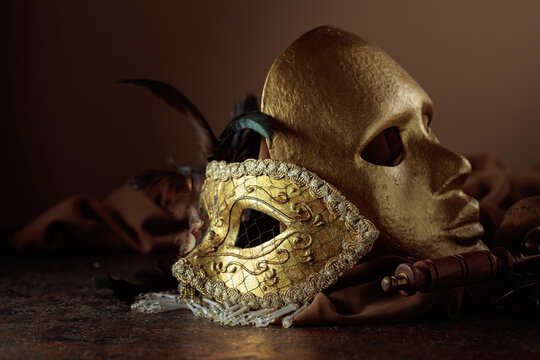 Golden carnival masks on a brown background.