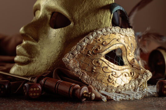 Golden vintage carnival masks with old wooden dices.