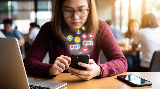 Young woman using smartphone in cafe with digital social media reaction icons floating above the screen, representing online connection and digital communication