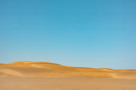 Vast golden desert sand dunes under a clear bright blue sky, scenic landscape view of arid terrain with soft rolling hills of sand, natural outdoor environment, sunny day, wide angle perspective
