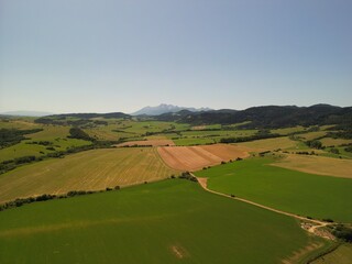 Słowacja - piękne pola z widokiem na góry Tatry, zdjęcie wykonae dronem. Pola, góry, Tatry, miasteczko, piękne miesjca © Konrad