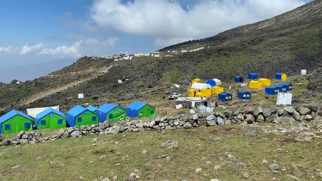 Mount Ararat base camp hosting expedition tents in wide view on a rocky slope in Turkey, illustrating trekking infrastructure, climber accommodation, camp logistics, and mountain tourism services
