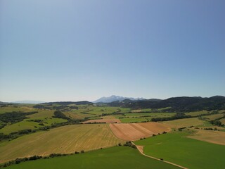 Słowacja - piękne pola z widokiem na góry Tatry, zdjęcie wykonae dronem. Pola, góry, Tatry, miasteczko, piękne miesjca © Konrad