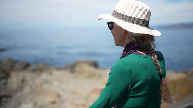 A senior woman enjoys the ocean view while walking on the boardwalk at Mac Kerricher State Park in Fort Bragg, California.
