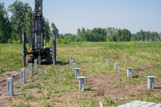 Diesel hammer drives concrete piles for a country house.