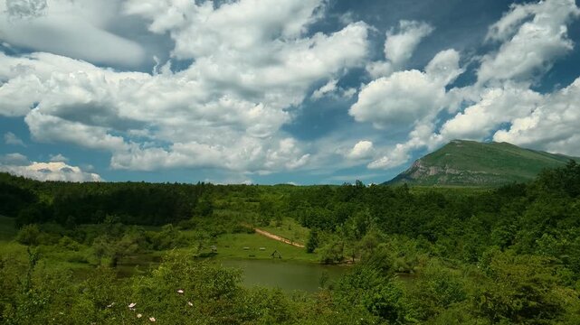 Cotton-like clouds drift across the horizon. Vrmdza Lake, Serbia