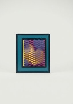 A rectangular object with a dark border and blue inner frame containing a grid of hexagonal holes. Behind the grid, glowing abstract shapes in yellow and purple are visible.