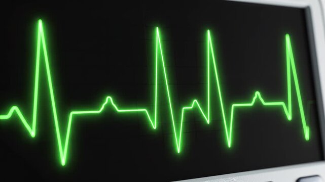 EKG heart monitor waveform pulsing with life in dark laboratory setting with subtle camera zoom