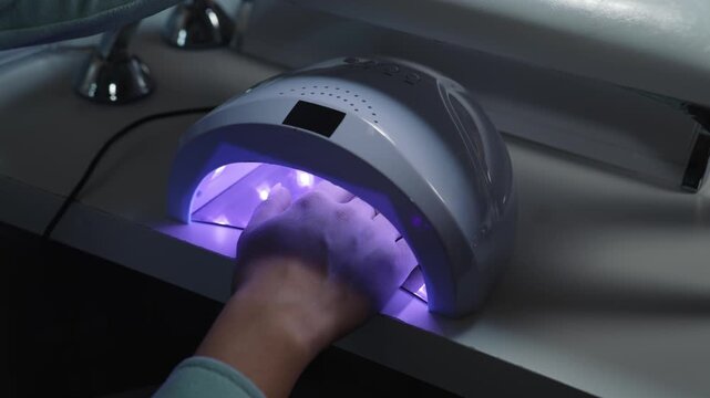 Full hand drying in ultraviolet lamp after gel application during salon manicure process
