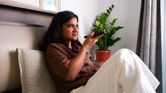 Young woman learning a new language using Google Translate on smartphone for AI powered translation and self study at home