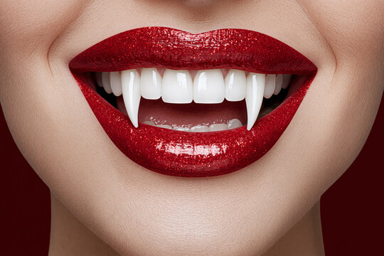 Close-up of glittery red lips with vampire fangs smiling, Halloween beauty portrait