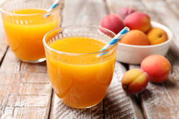 Apricot juice in glasses and fresh fruits on wooden table, closeup © New Africa