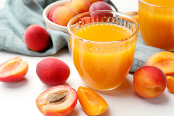Apricot juice in glasses and fresh fruits on white table, closeup © New Africa