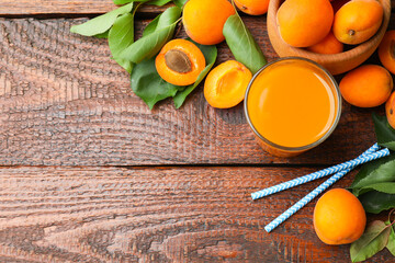 Apricot juice in glass, fresh fruits and drinking straws on wooden table, flat lay. Space for text © New Africa