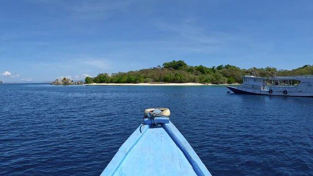 View of Labuan Bajo Harbor and Blue Boat Sailing Near Flores Island, Indonesia, Tropical Coastal Landscape.  