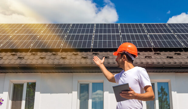 Installing solar panels on a house roof. Selective focus.