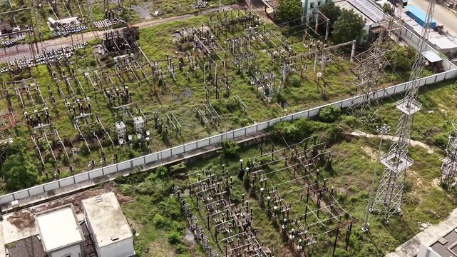 Power grid substation with transmission towers and switchgear from above