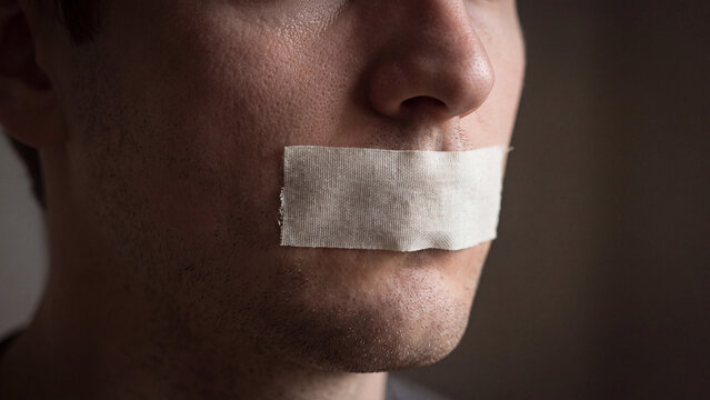 Censorship concept showing a man with textured skin and adhesive tape sealing his silent mouth.