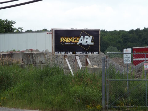 Gatineau, Quebec, Canada &ndash; June 28, 2026: An outdoor sign for "Pavage ABL" stands near a gravel yard, a chain-link fence, and concrete blocks on Bd Saint-Ren&eacute; E.