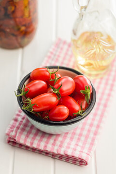 Fresh Cherry Tomatoes in a Bowl with Olive Oil and Preserved Jar on Kitchen Counter