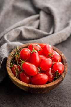 Fresh Cherry Tomatoes in Wooden Bowl on Kitchen Countertop, Close-Up Bright Red Produce