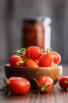 Fresh Cherry Tomatoes in Wooden Bowl on Rustic Tabletop Close-Up with Natural Kitchen Background