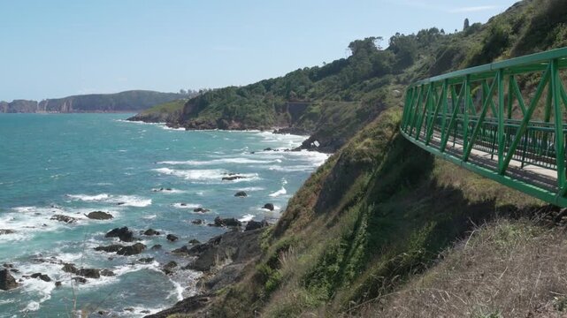 Pedestrian bridge over precipice with stunning view of Atlantic coast, ocean and rocky coast of Asturias Spain