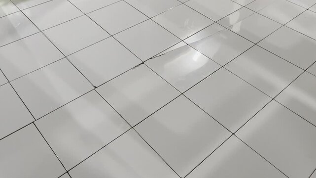 Glossy floor tiles with linear window light reflection