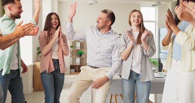 Teacher students celebrate success with applause in classroom. Happy group with mentor give high five and claps to mark celebration and success. Clear celebration and classroom teamwork concept.