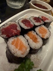 Maki sushi relleno de atún y salmón sobre un plato de cerámica blanco © Alex Manzanares