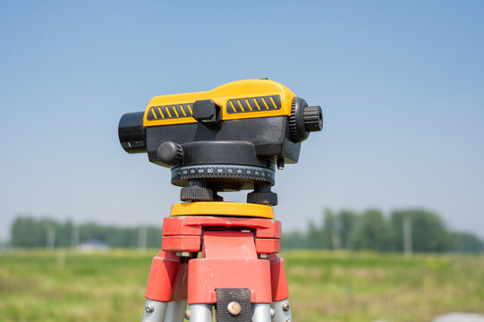Diesel hammer drives concrete piles for a country house. Surveying equipment on a tripod set up. 