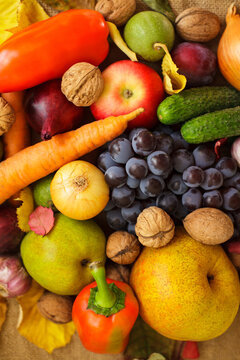 Vertical close up of fresh autumn harvest fruits vegetables and walnuts