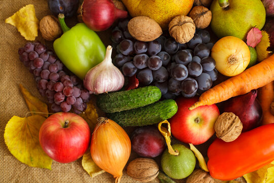 Close up of abundant autumn harvest fruits vegetables and nuts on burlap