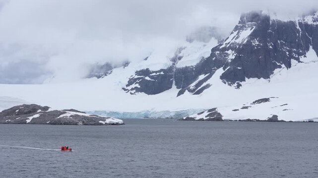 Port Lockroy Antarctic Peninsula Wide View From Cruise Ship. Large Mountain, Glacier, Moody Clouds. Small Tender Boat Drives Back, Antarctica