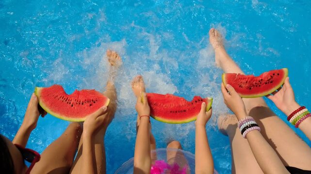 Children with watermelon near the pool. Selective focus.