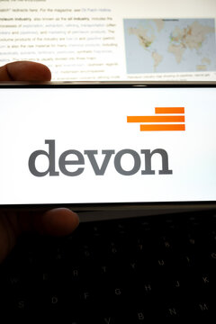 Person holding device showing devon energy corporation logo