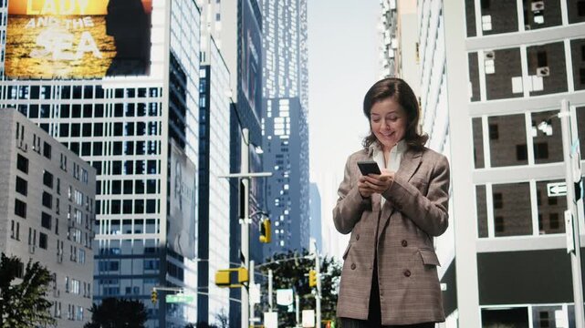 Excited businesswoman celebrates good news with a victory gesture on a city street; the ecstatic professional reacts to positive results on her smartphone.